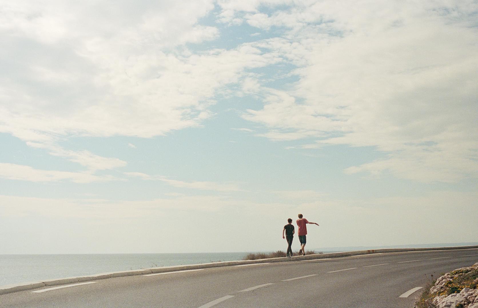 Deux personnes sur une route en bord de mer